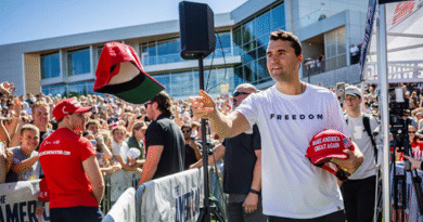 Charlie Kirk tossing a red "Make America Great Again" hat to a crowd at a rally